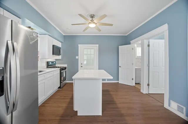 a kitchen with white cabinets and stainless steel appliances