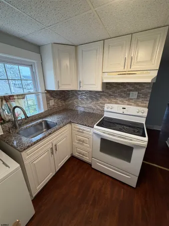 a kitchen with granite countertop wooden cabinets and white appliances