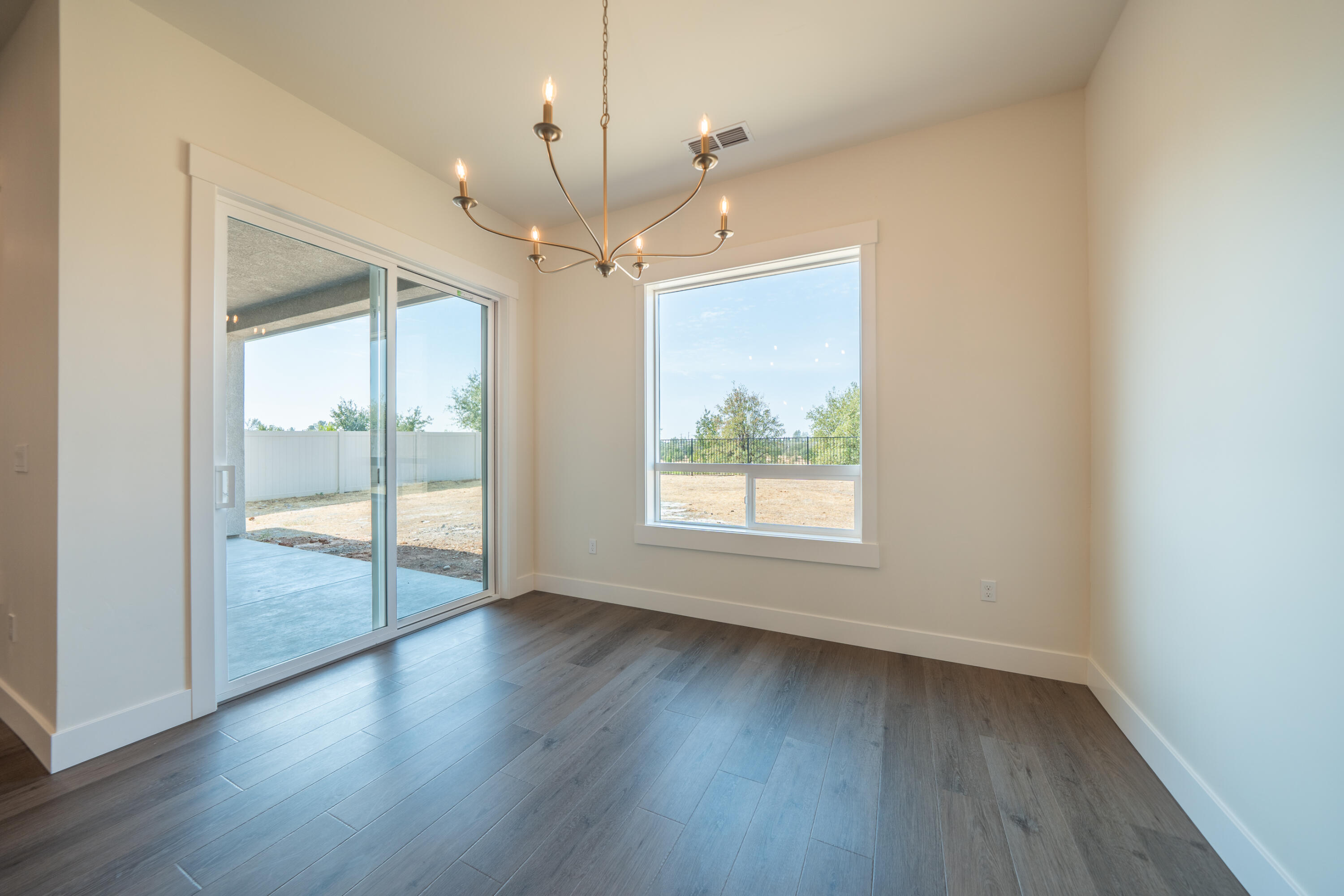 3792 Thomason Trail Redding, CA 96002 - Photo 12 of 42 an empty room with wooden floor and windows