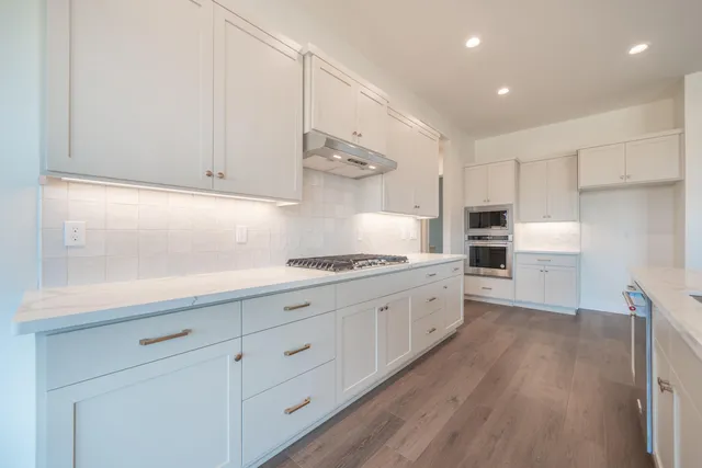 a kitchen with white cabinets and stainless steel appliances