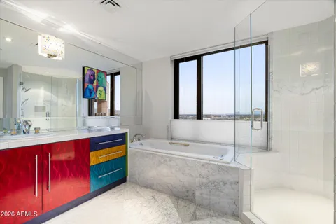 a spacious bathroom with a tub sink and mirror