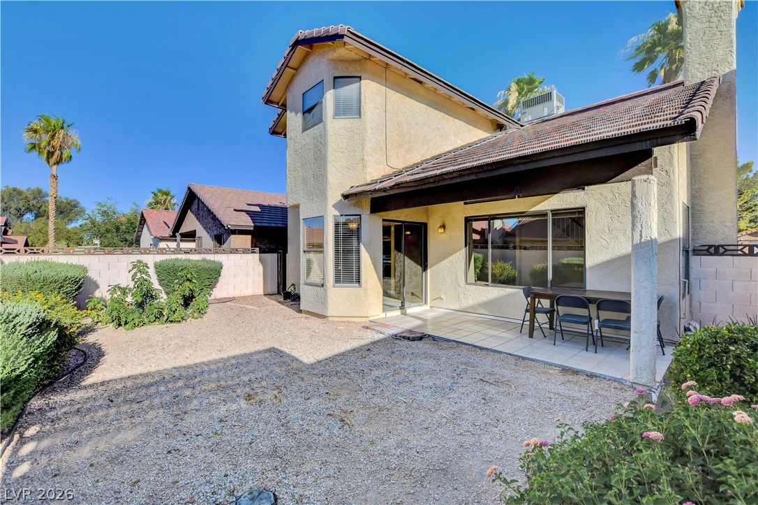 6440 Hartwood Road Las Vegas, NV 89108 - Photo 54 of 59 A private yard with a tiled patio and mature desert landscaping offers a tranquil outdoor retreat.