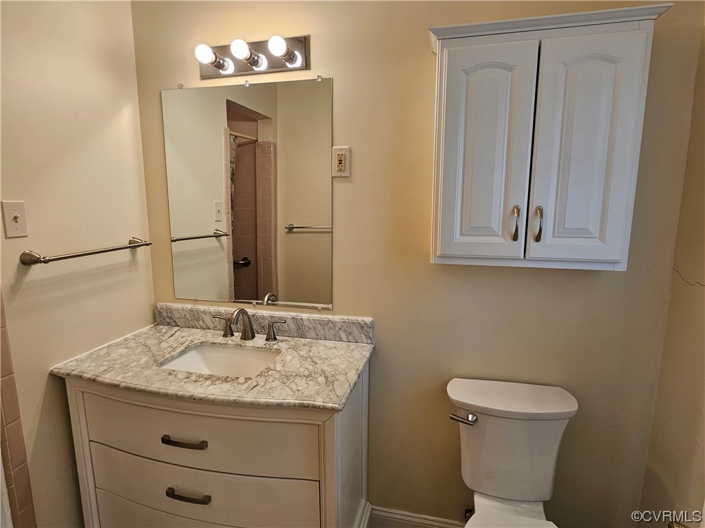 11310 Clement Town Road Amelia Court House, VA 23002 - Photo 23 of 32 a bathroom with a granite countertop sink a toilet and a mirror