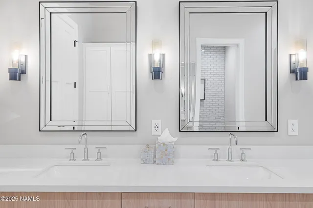 a bathroom with double vanity sinks and a mirror