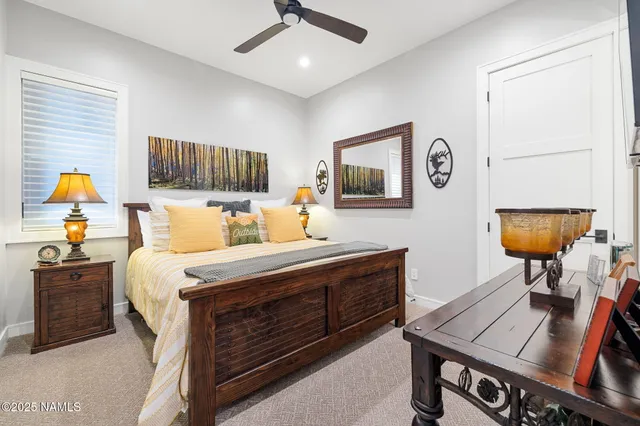 a bedroom with a bed a lamp on desk and a window