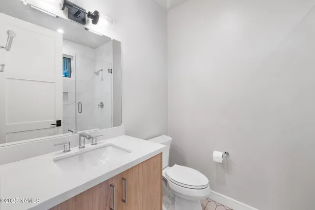 a bathroom with a granite countertop sink a toilet and a mirror