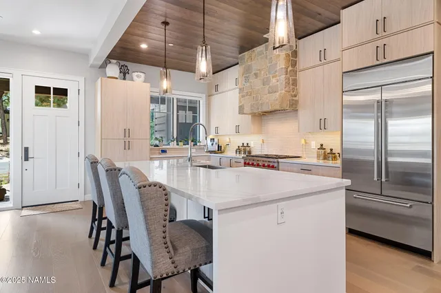 a kitchen with stainless steel appliances granite countertop a sink a stove and a refrigerator