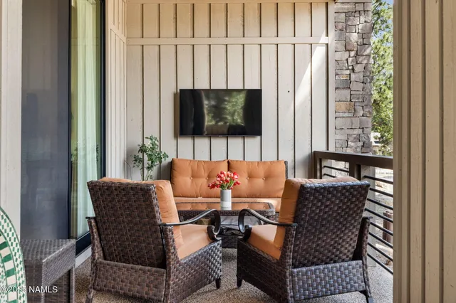 a living room with furniture a flat screen tv and a large window