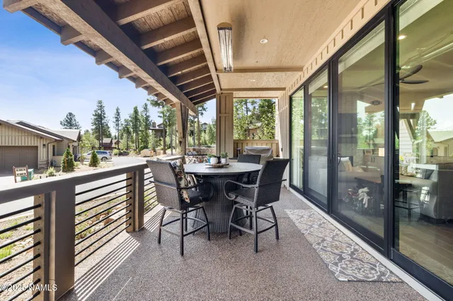 a dining room with furniture a rug and a floor to ceiling window