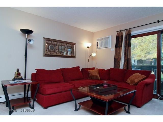 12 Parkside Court, Unit 4 Vernon Hills, IL 60061 - Photo 2 of 16 a living room with furniture a large window and a dresser