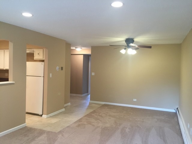 12 Parkside Court, Unit 4 Vernon Hills, IL 60061 - Photo 7 of 16 an empty room with chandelier fan and windows