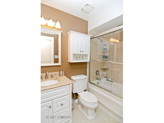 12 Parkside Court, Unit 4 Vernon Hills, IL 60061 - Photo 10 of 16 a bathroom with a toilet a sink a mirror and a shower