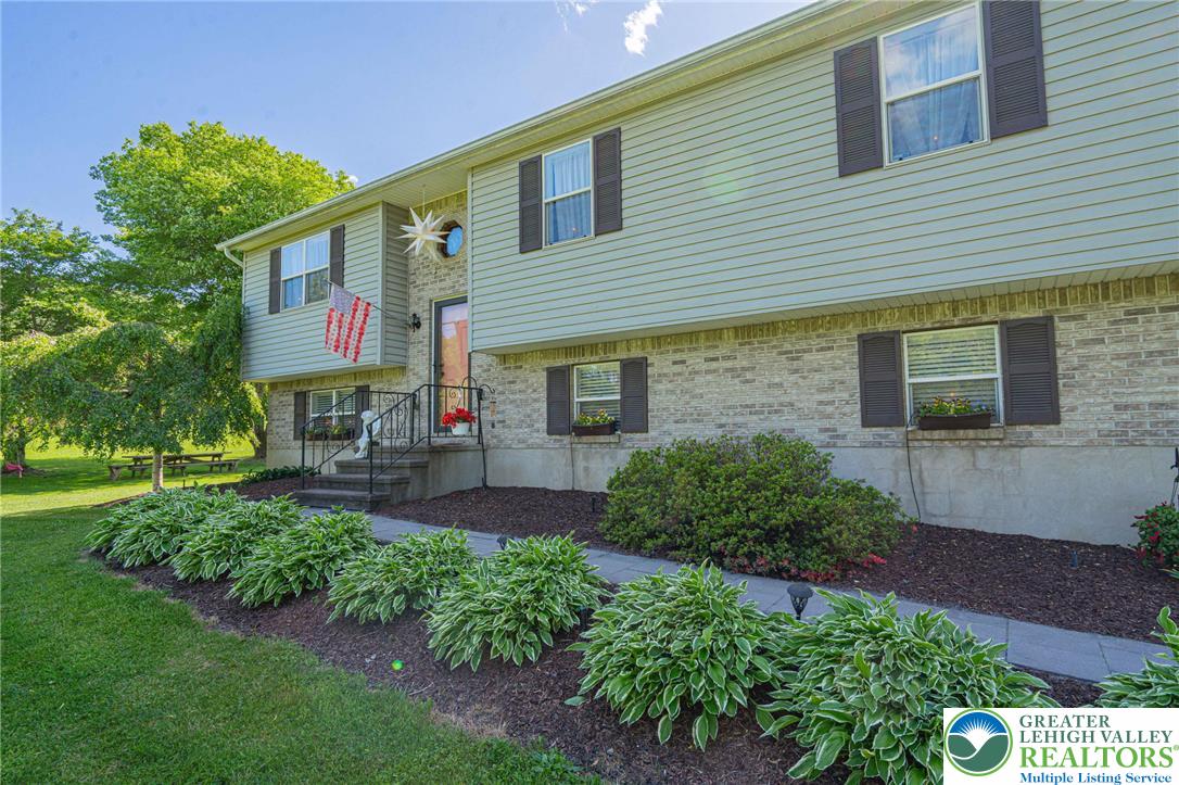 341 Lower Greenhill Road Kunkletown, PA 18058 - Photo 6 of 69 A welcoming façade with a brick and vinyl siding blend, framed by flourishing green landscaping.