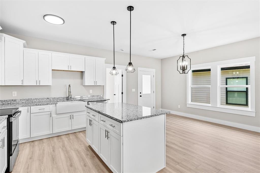152 Washington Street Dalton, GA 30721 - Photo 15 of 40 a kitchen with stainless steel appliances granite countertop a sink a stove a refrigerator and white cabinets with wooden floor