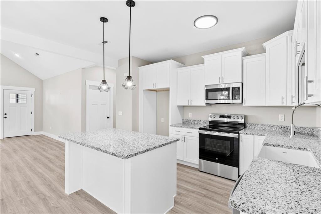 152 Washington Street Dalton, GA 30721 - Photo 17 of 40 a kitchen with stainless steel appliances granite countertop a sink a stove a refrigerator and island with wooden floor