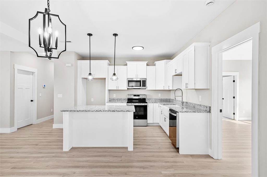 152 Washington Street Dalton, GA 30721 - Photo 19 of 40 a kitchen with white cabinets and stainless steel appliances