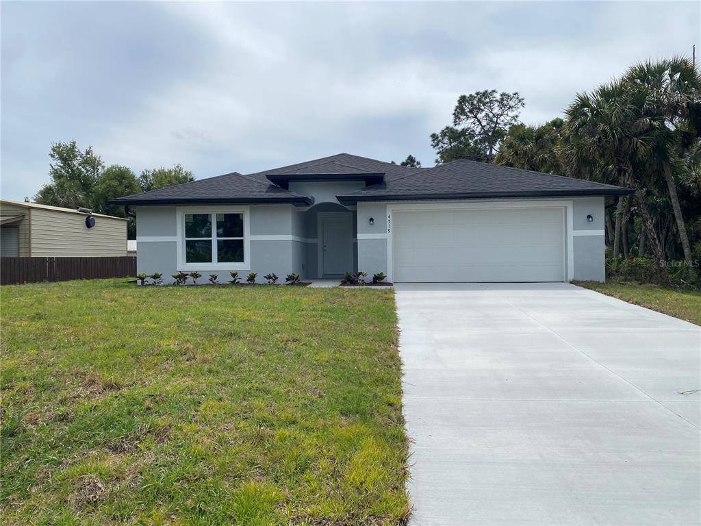 a front view of house with yard and trees in the background