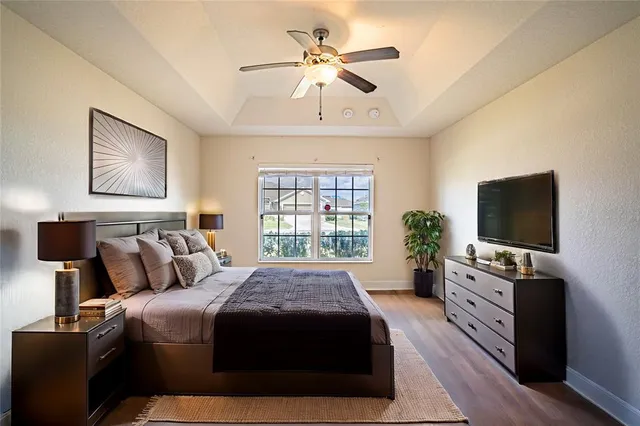 a spacious bedroom with a bed and a flat screen tv