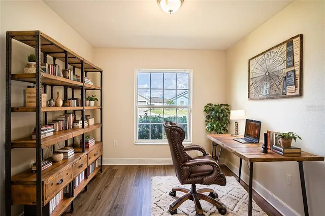 a view of a workspace with furniture and a bookshelf