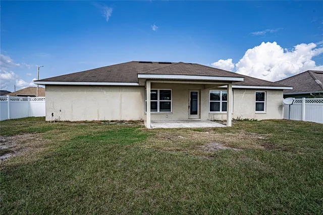 a backyard of a house with table and chairs