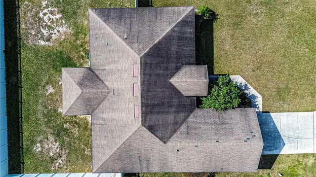 an aerial view of a house with a yard