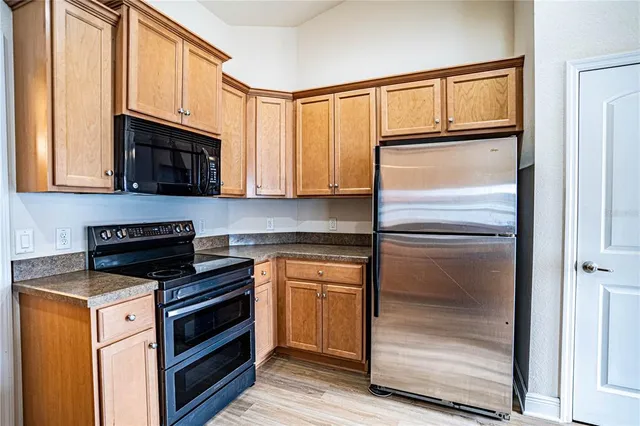 a kitchen with granite countertop cabinets stainless steel appliances and a window