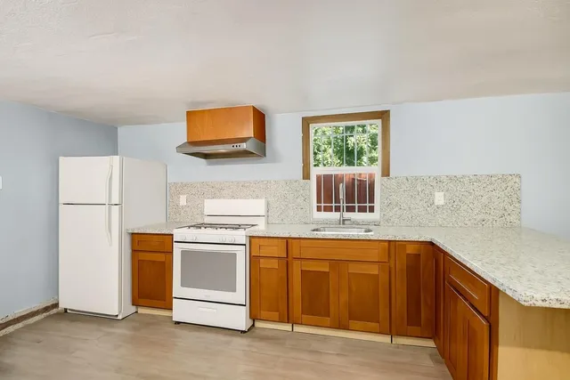 a kitchen with stainless steel appliances granite countertop a stove a sink and a refrigerator
