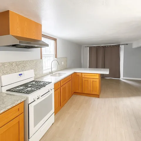 a kitchen with granite countertop a stove and a sink