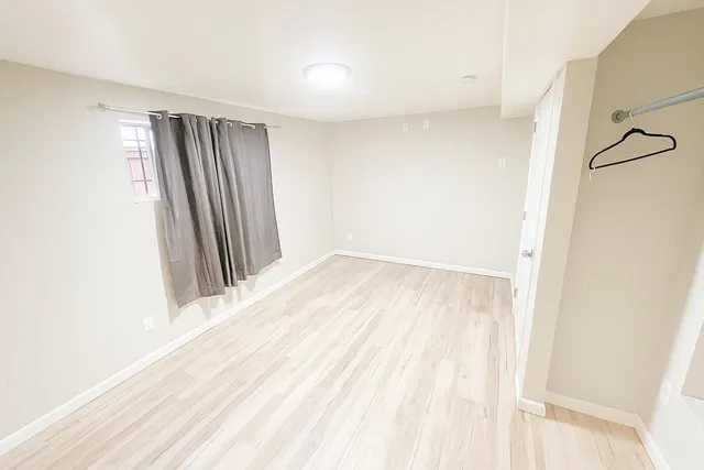 a view of a room with a white wall and a window