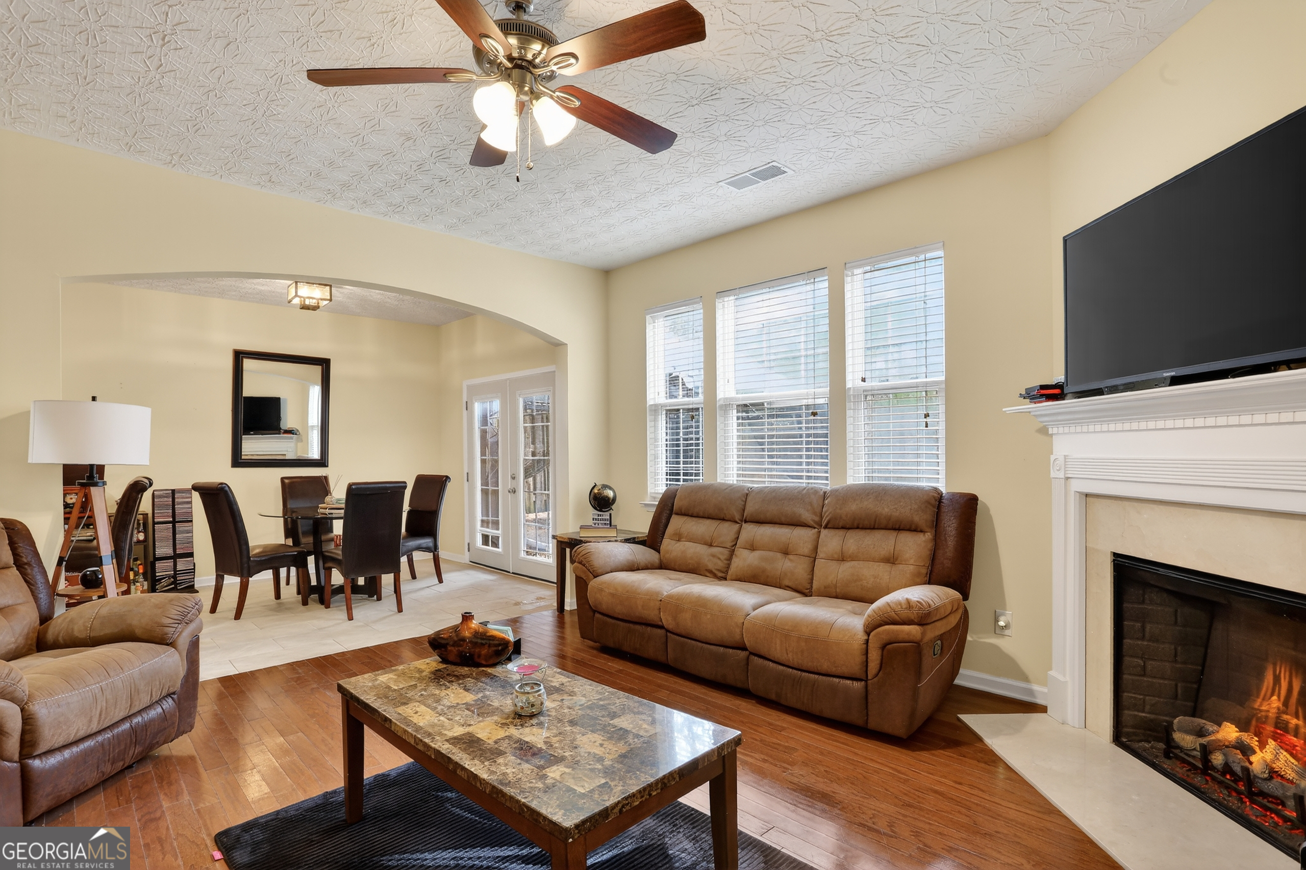 5556 Cascade Run South Fulton, GA 30336 - Photo 11 of 35 a living room with furniture a fireplace and a flat screen tv