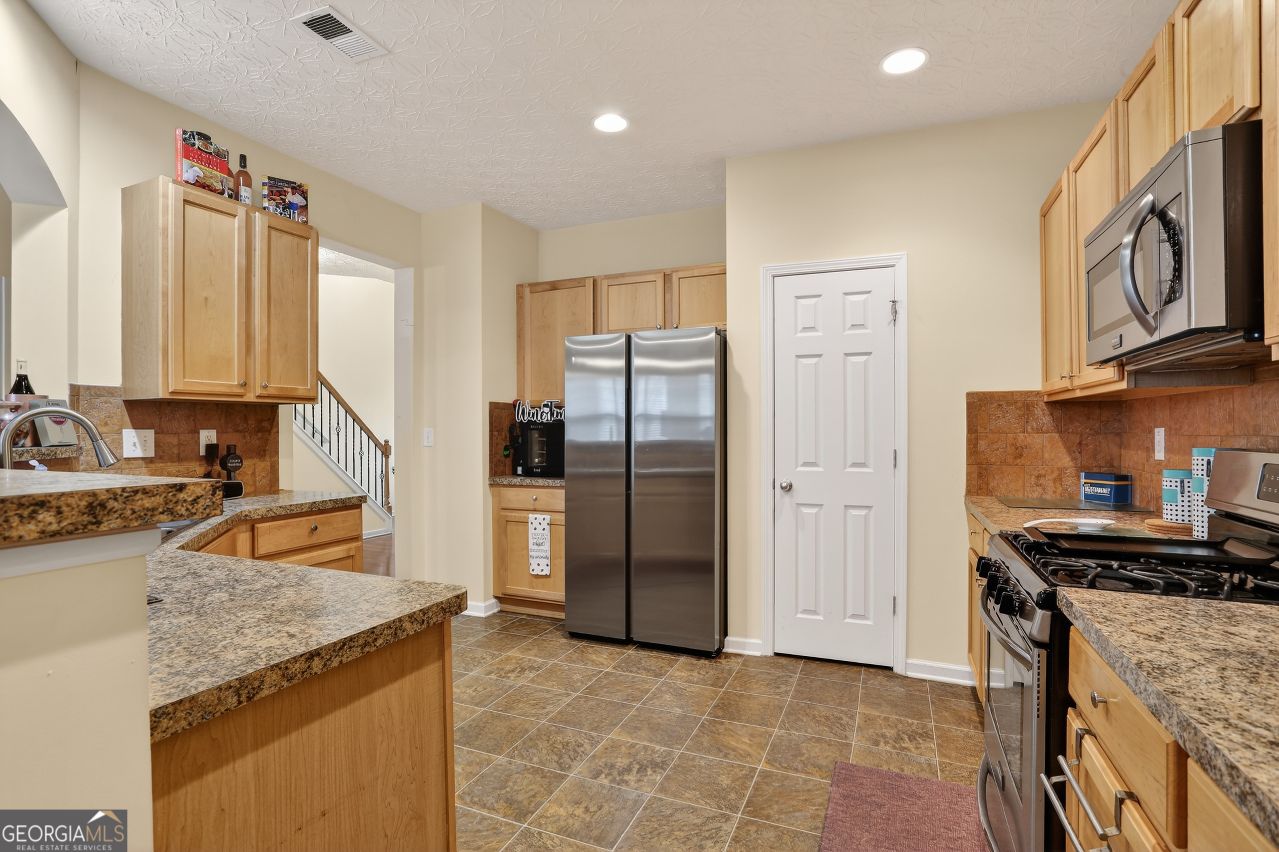 5556 Cascade Run South Fulton, GA 30336 - Photo 16 of 35 a kitchen with stainless steel appliances granite countertop a refrigerator a stove and a sink with wooden cabinets