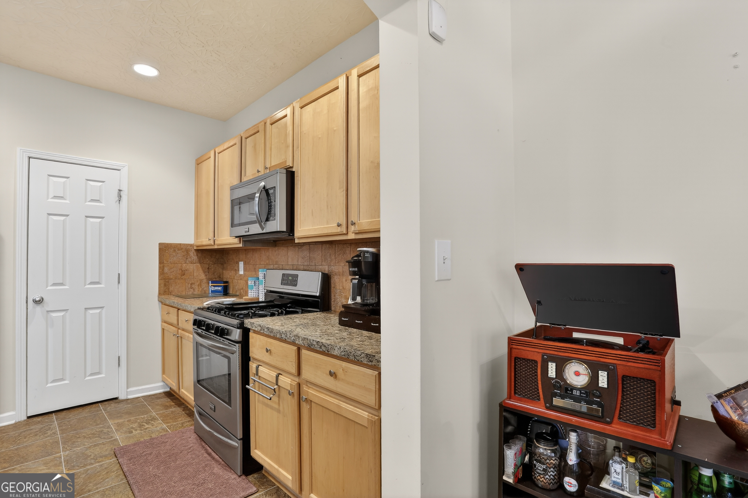 5556 Cascade Run South Fulton, GA 30336 - Photo 17 of 35 a kitchen with stainless steel appliances a stove microwave and cabinets