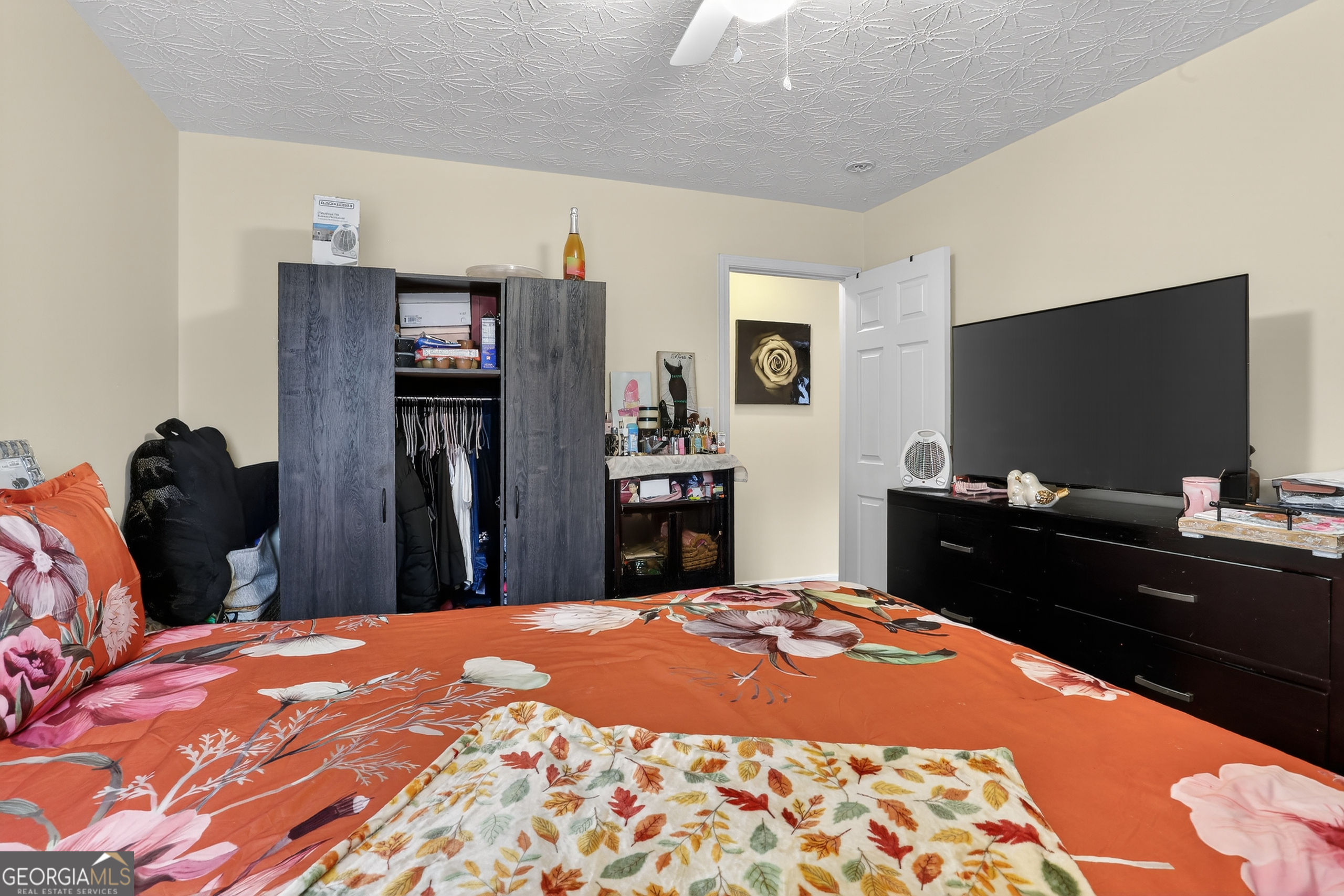 5556 Cascade Run South Fulton, GA 30336 - Photo 23 of 35 a bedroom with a bed and a flat tv screen on dresser