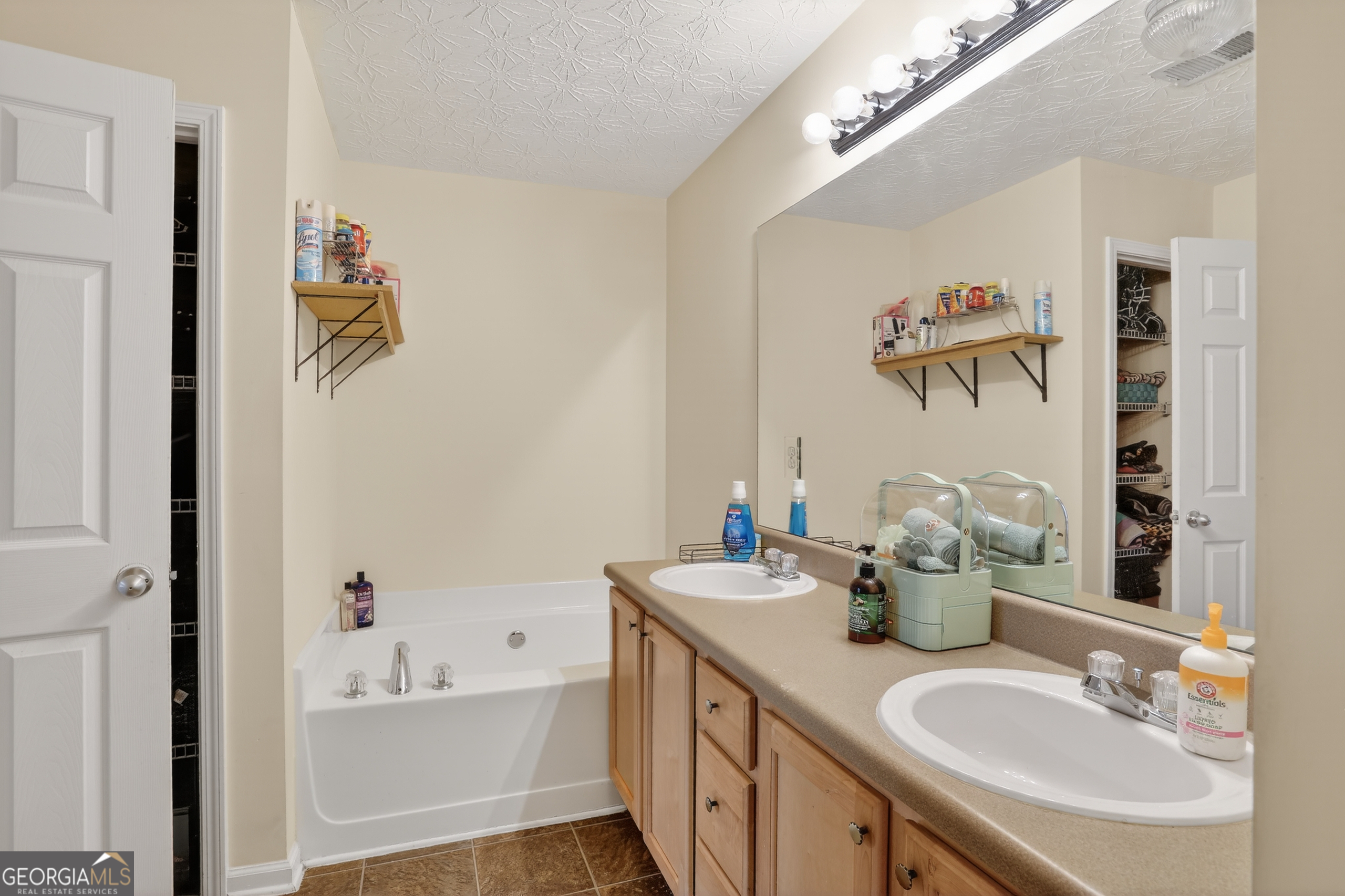 5556 Cascade Run South Fulton, GA 30336 - Photo 27 of 35 a bathroom with a sink a mirror and a bathtub