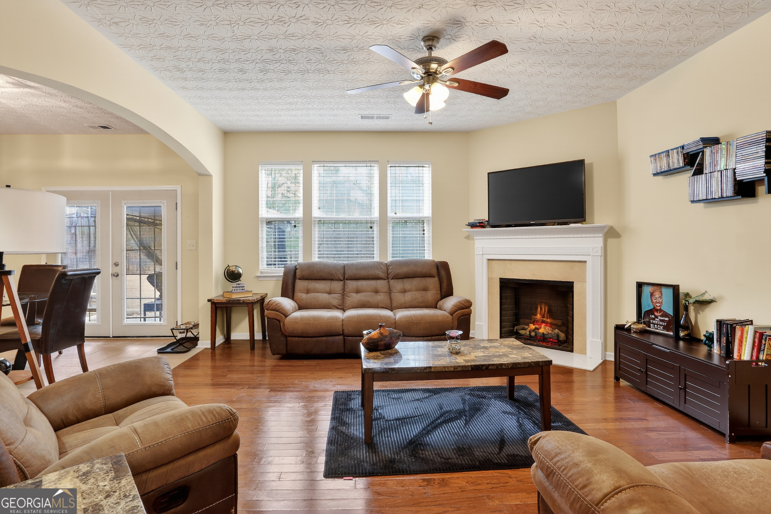 5556 Cascade Run South Fulton, GA 30336 - Photo 6 of 35 a living room with furniture a fireplace and a flat screen tv