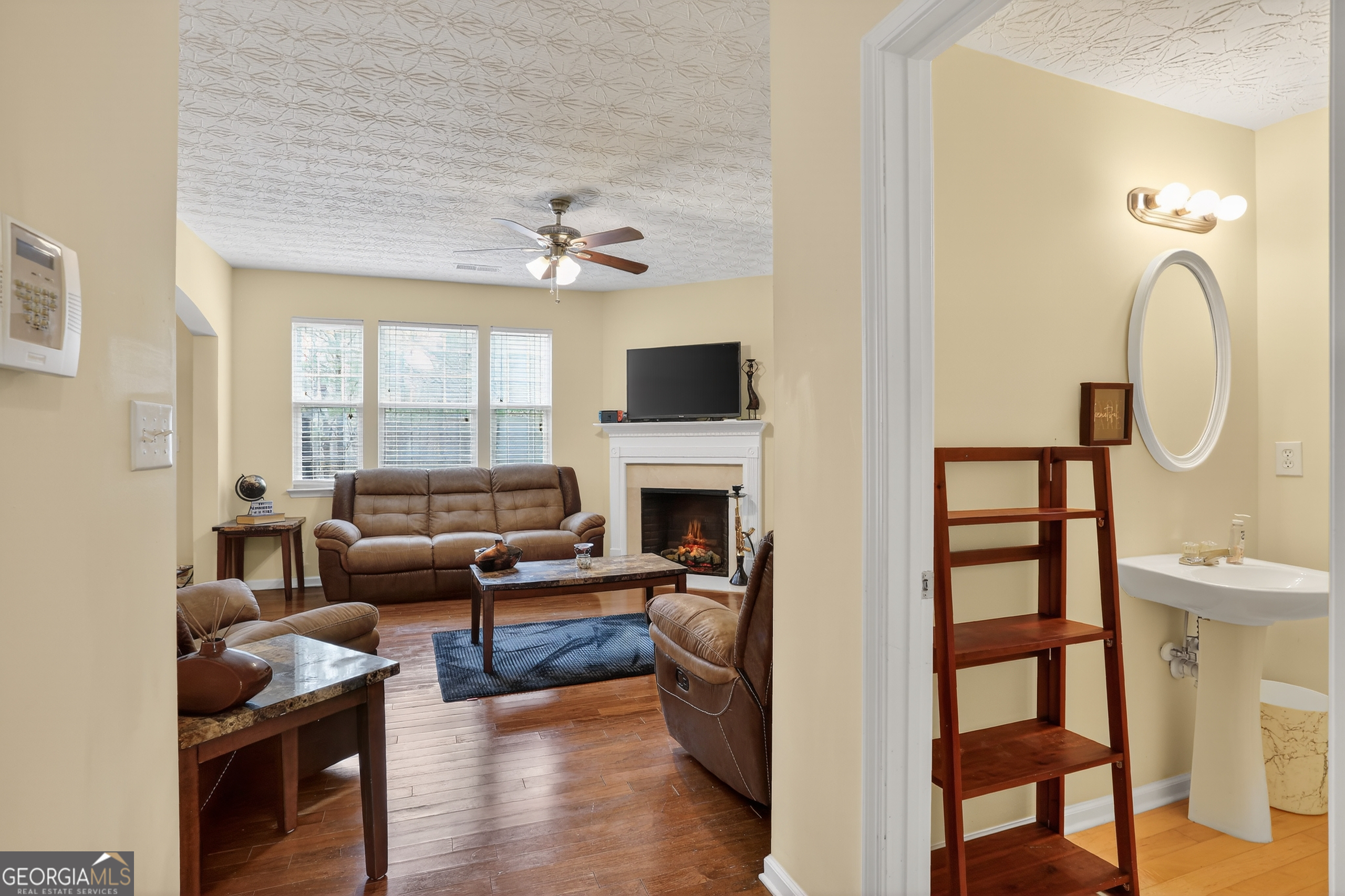 5556 Cascade Run South Fulton, GA 30336 - Photo 8 of 35 a living room with furniture a fireplace and a flat screen tv