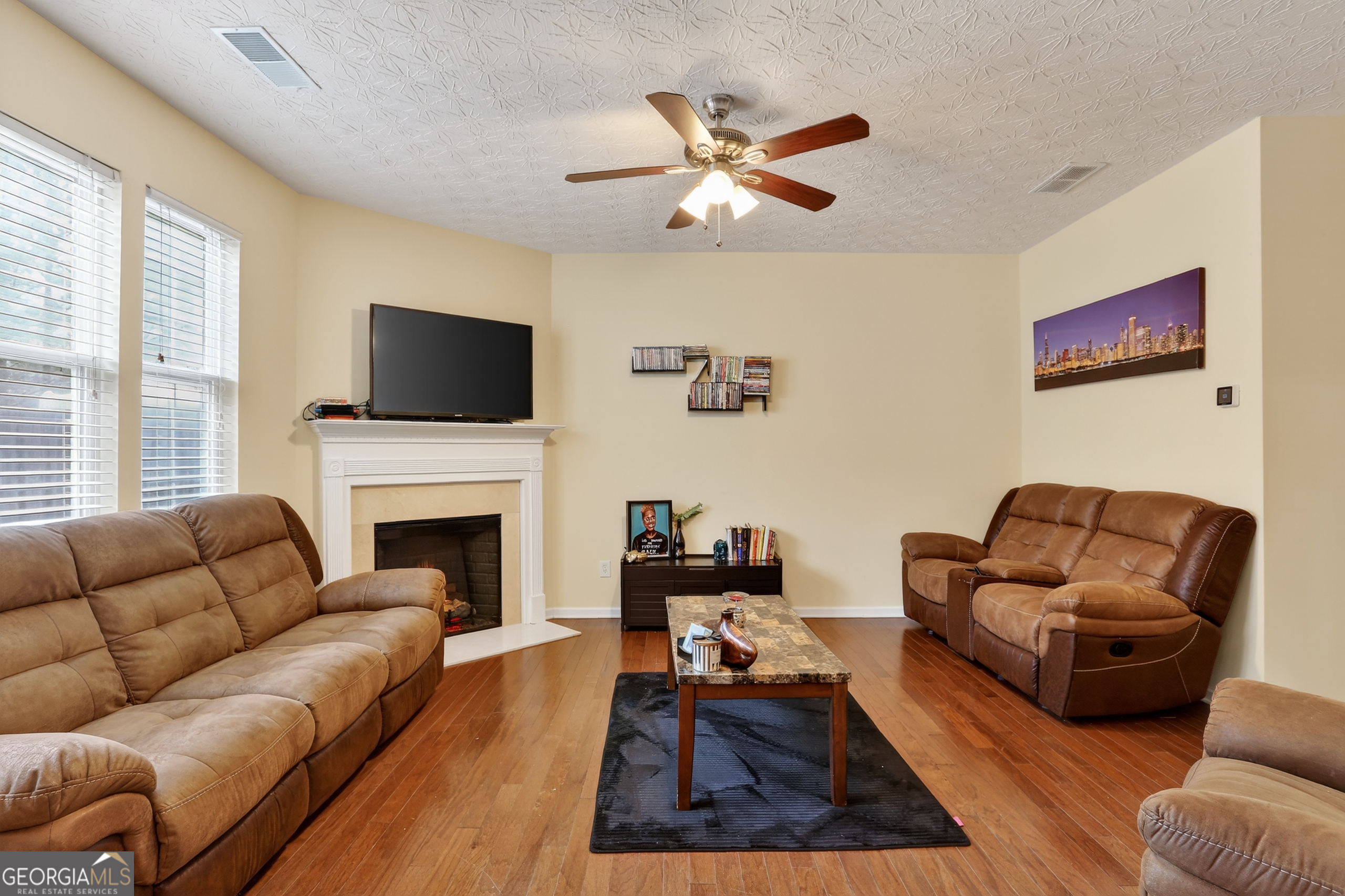5556 Cascade Run South Fulton, GA 30336 - Photo 9 of 35 a living room with furniture a flat screen tv and a fireplace