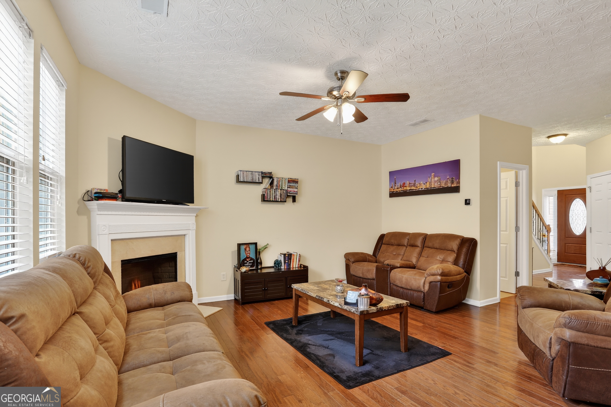 5556 Cascade Run South Fulton, GA 30336 - Photo 10 of 35 a living room with furniture a fireplace and a flat screen tv