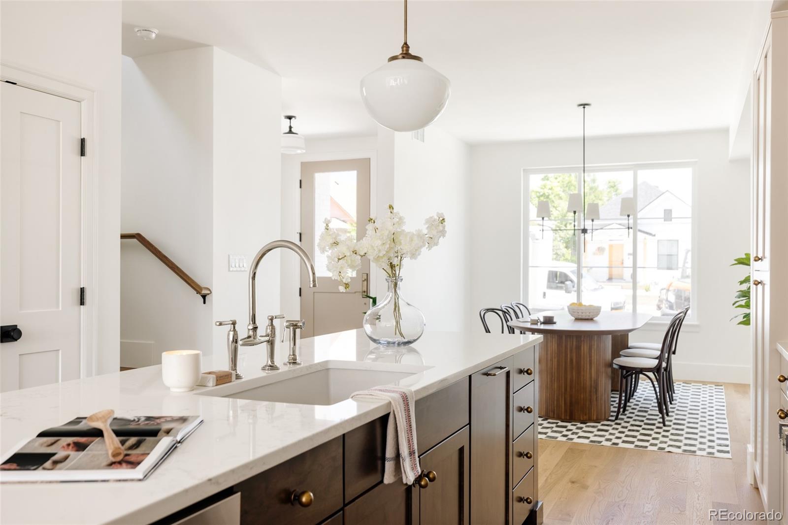 4131 Quivas Street Denver, CO 80211 - Photo 9 of 44 a kitchen with a sink a stove and a dining table