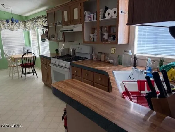 a kitchen with stainless steel appliances granite countertop a stove top oven a sink dishwasher and cabinets with wooden floor