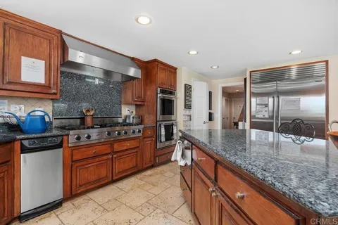 a large kitchen with granite countertop a sink and cabinets