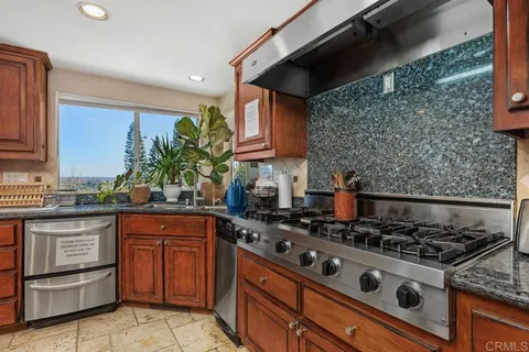a kitchen with stainless steel appliances granite countertop a stove a sink and a microwave