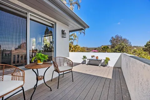 a balcony with wooden floor and outdoor seating