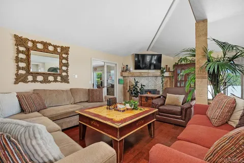a living room with furniture a flat screen tv and a wall painting