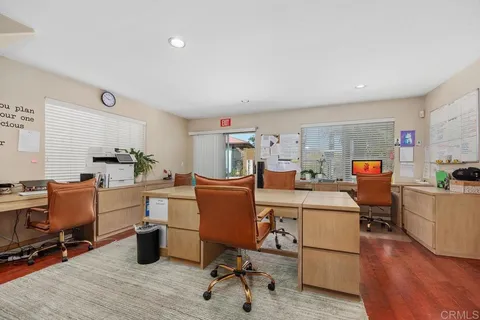 a room with furniture a rug kitchen view and a chair