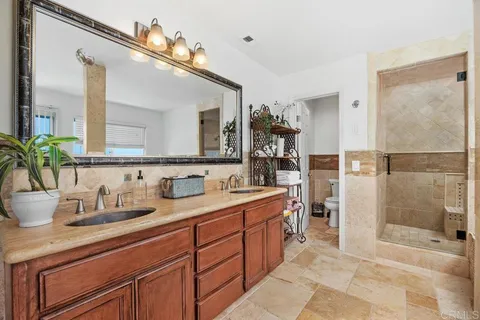 a bathroom with a double vanity sink mirror and shower