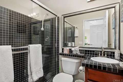 a bathroom with a toilet a sink and mirror