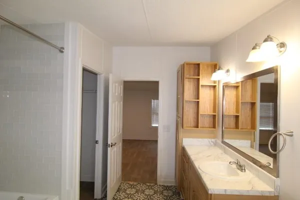 a bathroom with a tub sink shower and mirror