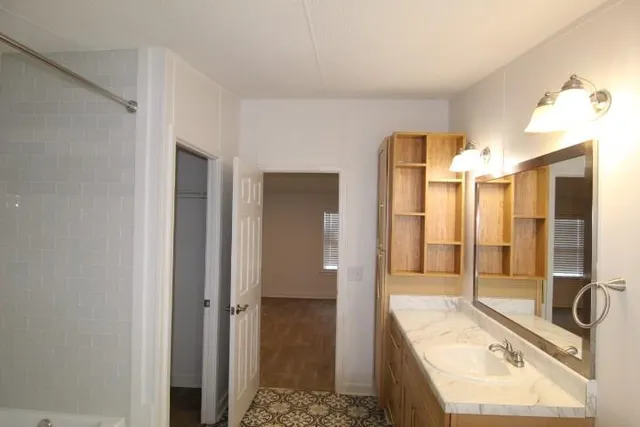 a bathroom with a tub sink shower and mirror