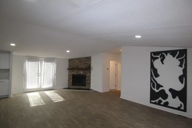 an empty room with windows and fireplace
